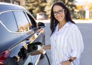 woman plugging in electric vehicle